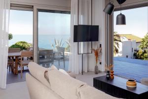 een woonkamer met een bank en een eetkamer bij AGAVE HILL LUXURY HOUSE in Chania