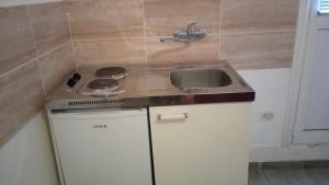 a small kitchen with a sink and a stove at Two in Petrovac na Moru