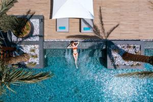 Eine Frau im Bikini ist im Schwimmbad. in der Unterkunft Amanti, MadeForTwo Hotels - Ayia Napa in Ayia Napa