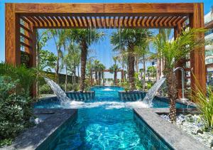 una piscina con cascata in un cortile alberato di Amanti, MadeForTwo Hotels - Ayia Napa a Ayia Napa