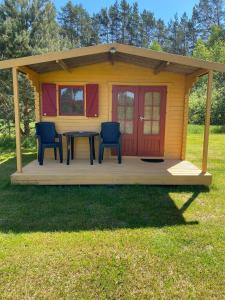una casa pequeña con una mesa y sillas en una terraza en Mini Camping, en Kabli
