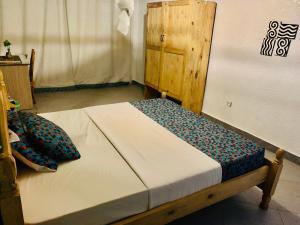 1 dormitorio con 1 cama con marco de madera en Tea House BNB, en Kigali