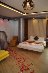 a bedroom with a bed with red flowers on the floor at Vila One Beach Hotel in Durrës