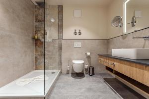 a bathroom with a tub and a sink and a toilet at Hotel & Restaurant Rödersaal in Großröhrsdorf