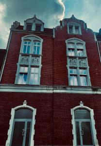 un grand bâtiment en briques rouges avec trois fenêtres dans l'établissement Kamienica5, à Chorzów