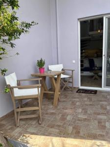 drewniany stół i krzesła na patio w obiekcie OASIS rooms w mieście Karistos
