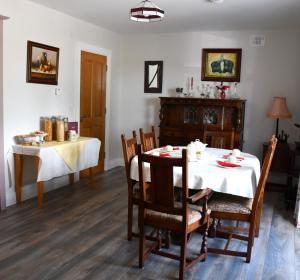 ein Esszimmer mit einem Tisch, einem Tisch und Stühlen in der Unterkunft Kilbawn Country House in Kilkenny