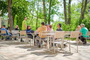 a group of people sitting at tables in a park at Philippus Inklusionshotel Leipzig in Leipzig