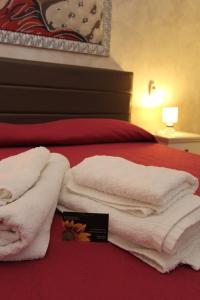 Una cama con toallas blancas encima. en Villa Raggio di Sole parcheggio privato, en Porto Cesareo