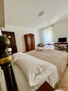 アグリジェントにあるCittà Dei Templi GuestHouseのベッドルーム1室(白いシーツとテーブル付)