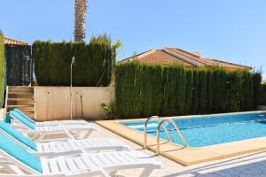 a swimming pool with lounge chairs next to a fence at Mazarron Country Club Resort in Mazarrón