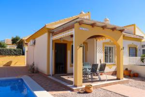 a villa with a pool and a house at Mazarron Country Club Resort in Mazarrón