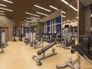 a gym with a lot of treadmills and machines at Pullman Yantai Center in Yantai