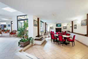 a waiting room with red chairs and tables in a hospital at Hotel Villa Lina in Loano