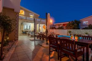 un patio avec une table et des chaises et une piscine dans l'établissement Villa Karmen - Poolhouse, à Vir