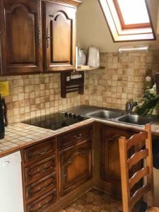 a kitchen with wooden cabinets and a sink at Adorable Chalet Sur le lac de Payolle in Campan