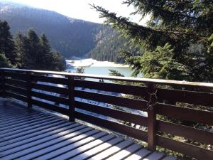 a wooden bench with a view of a river at Adorable Chalet Sur le lac de Payolle in Campan