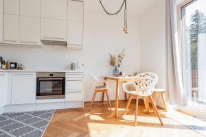 a kitchen with white cabinets and a table and chairs at Bienenkunde Lunz in Lunz am See