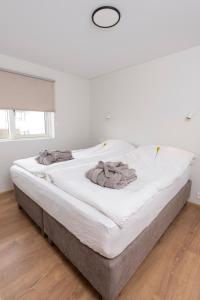 a large white bed in a room with white walls at Lundur Apartments in Reykjavík