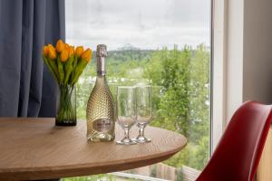 una botella de champán y dos copas en una mesa con una ventana en Lundur Apartments en Reikiavik