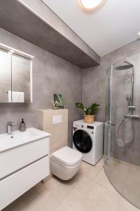 een badkamer met een toilet en een wasmachine bij Lundur Apartments in Reykjavík