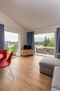 a living room with a couch and a table and a television at Lundur Apartments in Reykjavík