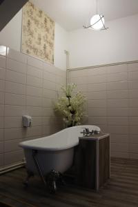 a bathroom with a tub and a vase of flowers at Hotel Funnytime in Bucharest