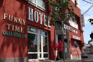 een rood gebouw met de voorkant van een winkel bij Hotel Funnytime in Boekarest