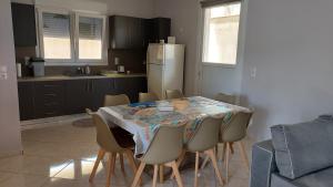 a kitchen with a table with chairs and a refrigerator at Gianni & Sophia airport house in Artemida