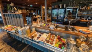 a buffet line with food and a sink in a restaurant at Snow Resort Kirkenes in Kirkenes