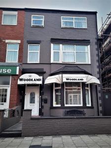 a brown building with umbrellas in front of it at The Woodland Hotel in Blackpool