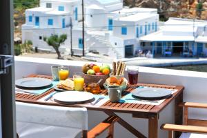 una mesa con desayuno en el balcón en Harmony View Lux studio with stunning Sea Views, en Sifnos