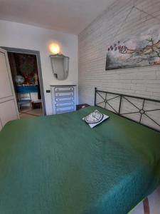 een slaapkamer met een bed met een groene sprei bij La casa nella roccia in Napels