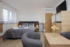a bedroom with a bed and two chairs and a table at Willa Szamotulanka - Pokoje Wakacyjne Rewal - Plac Zabaw & Grill - by Noclegi Renters in Rewal