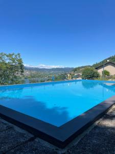 a large swimming pool with blue water at Lake Apartment Ischia Green, Lago di Caldonazzo in Tenna 