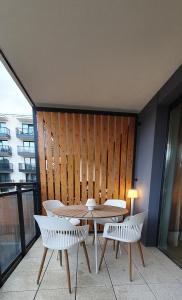 a table and chairs on a balcony with a wooden wall at Holiday Home Bel Mare 205e in Międzyzdroje