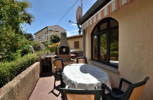 a patio with a table and chairs and a fireplace at Apartment Luna in Poreč