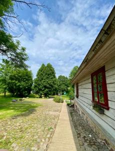 a path next to a building with trees in the background at In heart of Trakai you'll find authentic Karaim house in Trakai