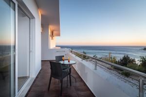 a balcony with a table and a view of the ocean at Porto Belissario in Ferma