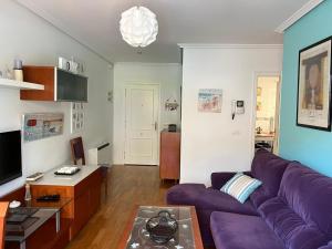 salon z fioletową kanapą i stołem w obiekcie TERRAZA PLAYA BAIONA w mieście Baiona