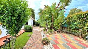 a garden with a brick walkway and palm trees at Salento Sunny House in Leporano +24 photos