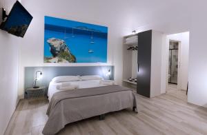 a bedroom with a bed and a painting on the wall at Nà Nonna Affittacamere in Favignana
