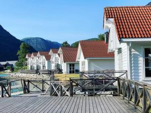 Skjolden Resort في سكوجلدن: سطح خشبي مع مجموعة من المنازل والجبال