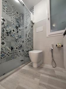 a bathroom with a toilet and a glass shower at Nà Nonna Affittacamere in Favignana