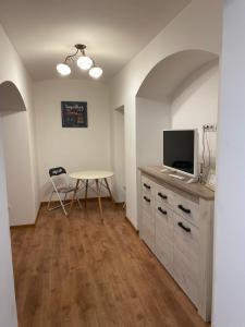 a room with a table with a tv and a table with a table at Wall St House in Sibiu