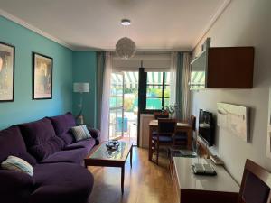 salon z fioletową kanapą i stołem w obiekcie TERRAZA PLAYA BAIONA w mieście Baiona