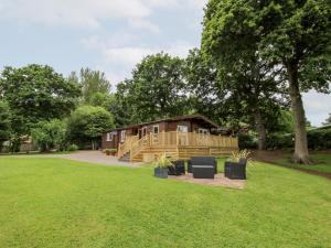 Cabaña de madera en un parque con césped en The Log Cabin en Tenbury