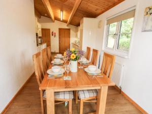 a dining room with a wooden table and chairs at The Log Cabin in Tenbury