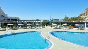 uma grande piscina com cadeiras e guarda-sóis num resort em Gran Amadores em Amadores