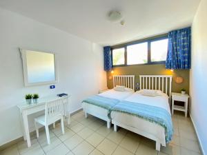 a bedroom with a bed and a desk and a mirror at Gran Amadores in Amadores